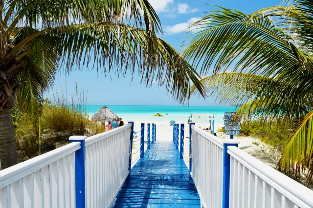 Pasarela de madera hacia una playa turquesa del Caribe